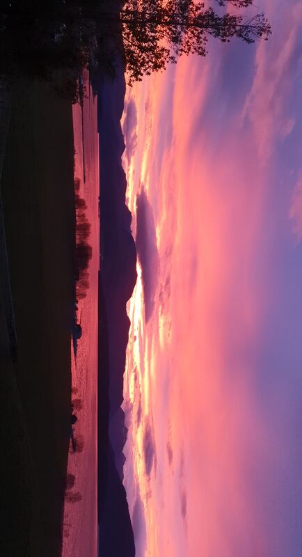 Fargerik solnedgang over fjell og fjord