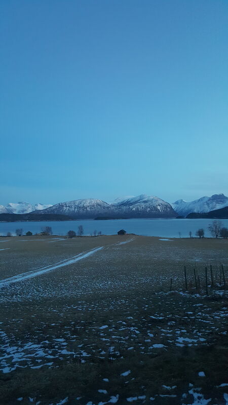 Vinterlandskap med snødekte fjell og fjord
